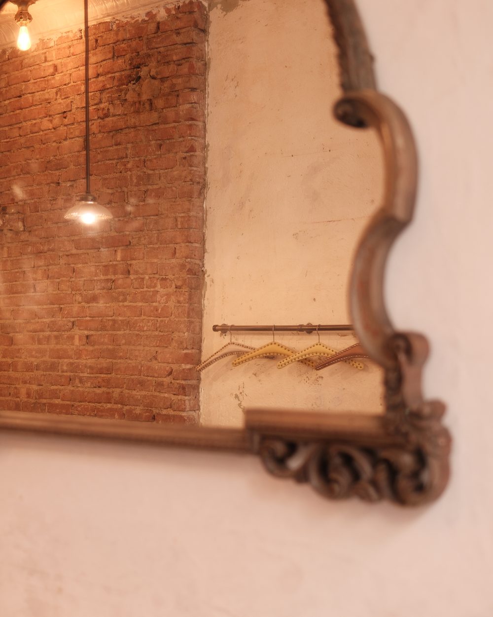 The carved mirror on the brick wall inside the café
