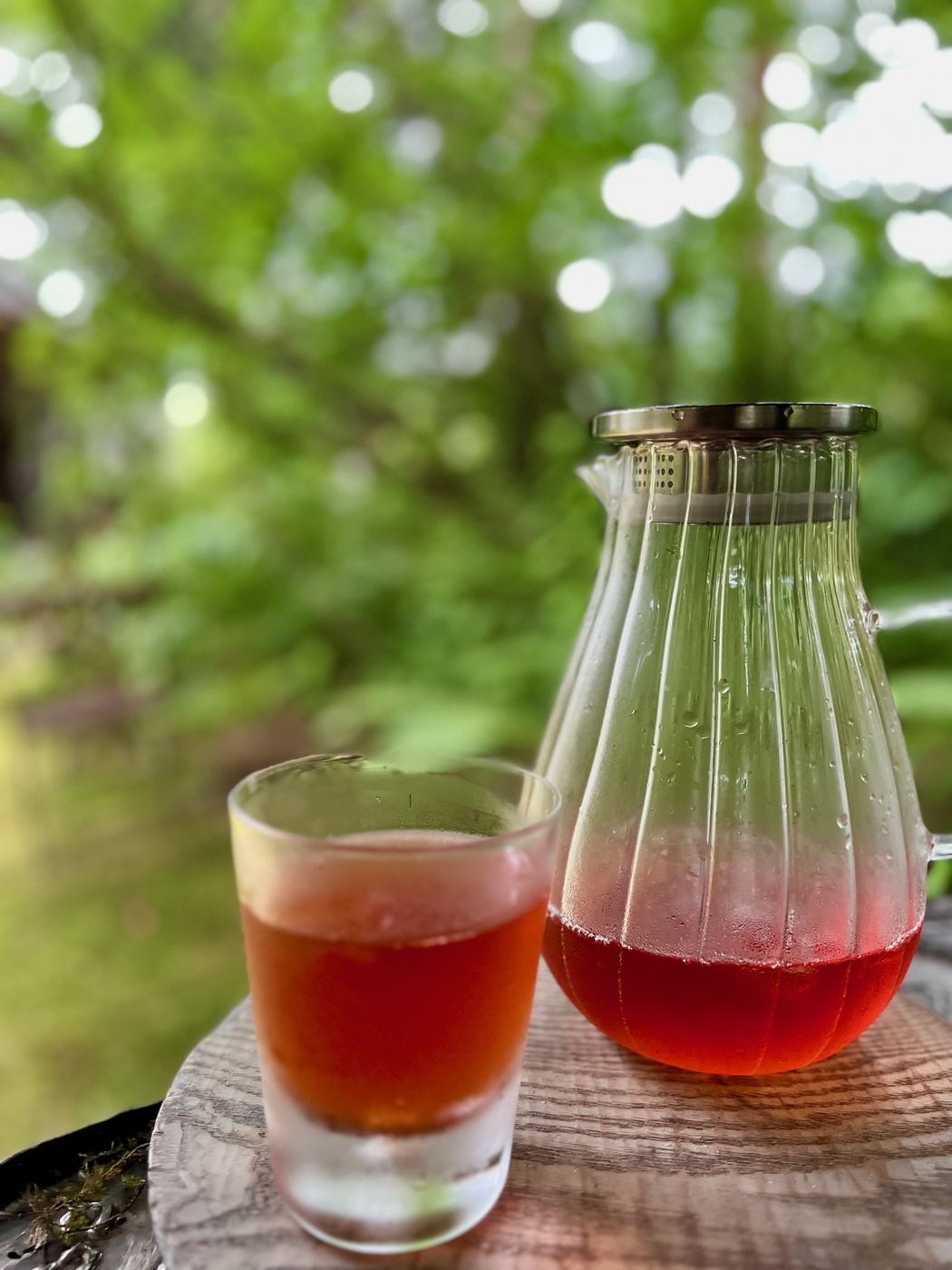 Iced Rooibos Blossom tea in a glass and carafe outdoors