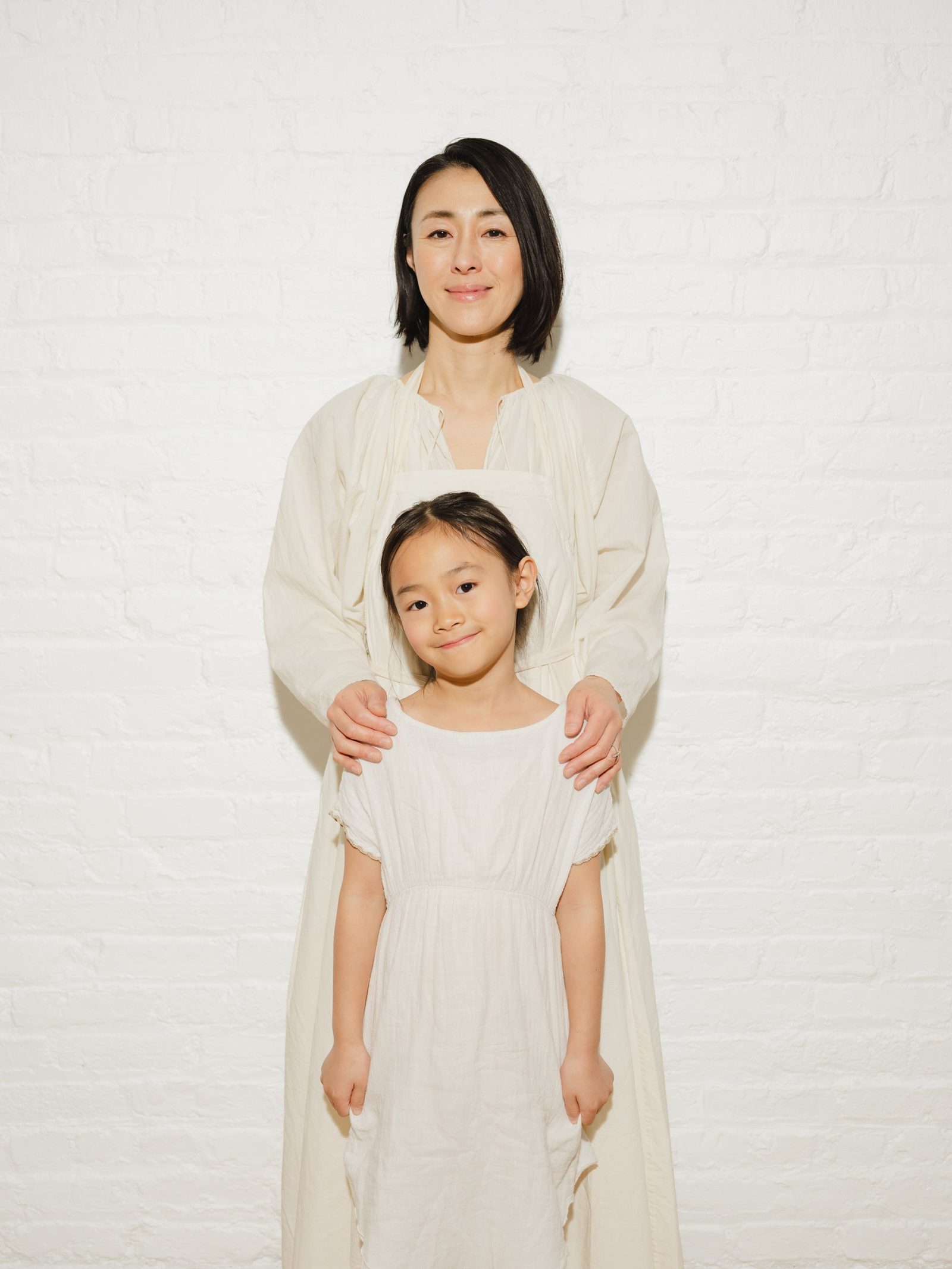 Yuki Hayakawa standing behind her daughter Noé, both in white